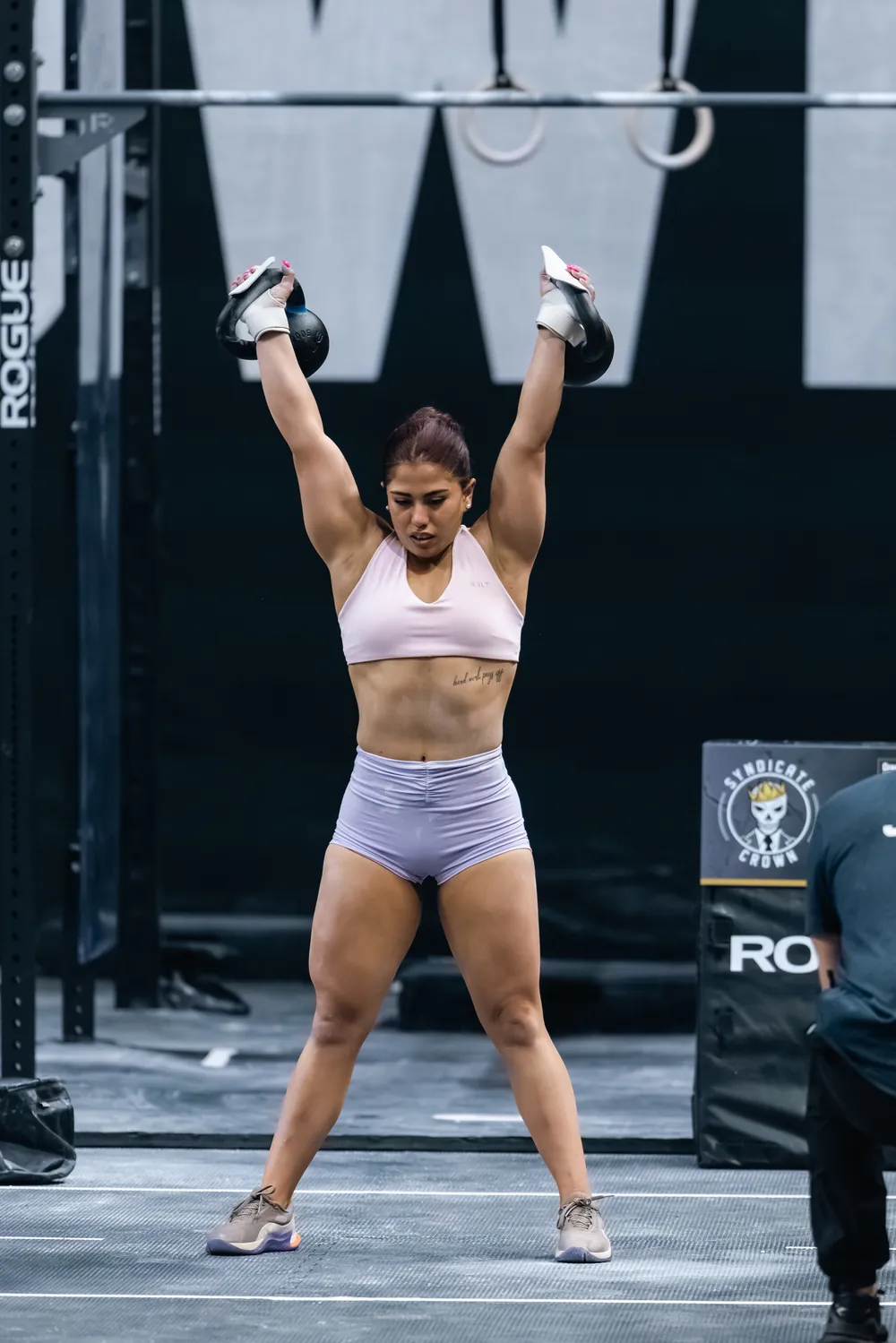Kilya Marchant levantando dos kettlebells sobre la cabeza